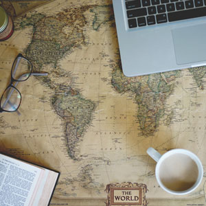 Picture of map with computer, coffee and book placed on it