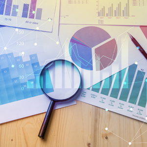 Magnifying glass laying over reports and graphs