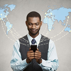 Picture of man sending virtual correspondence to countries pictured on a map behind him