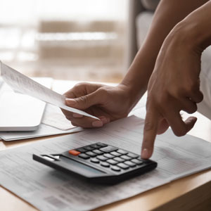 Picture of hands using a calculator and holding a receipt