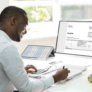 Picture of man working at desk with laptop and calculator