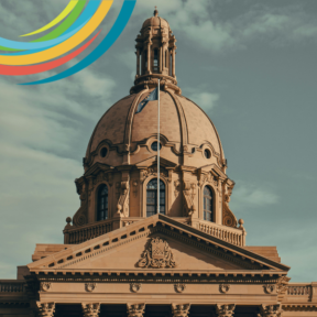 A partial image of the Legislative Assembly of Alberta in Calgary, Alberta. The Provincial flag is flying at full mast. 