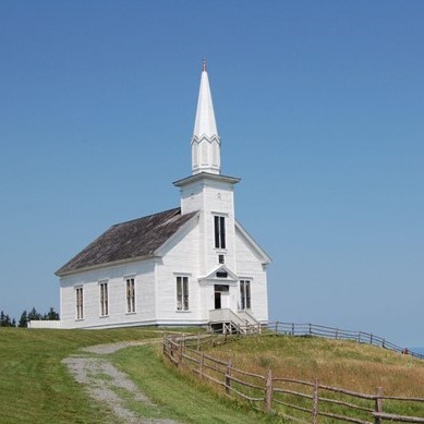Picture of a white church overlooking a body of water.