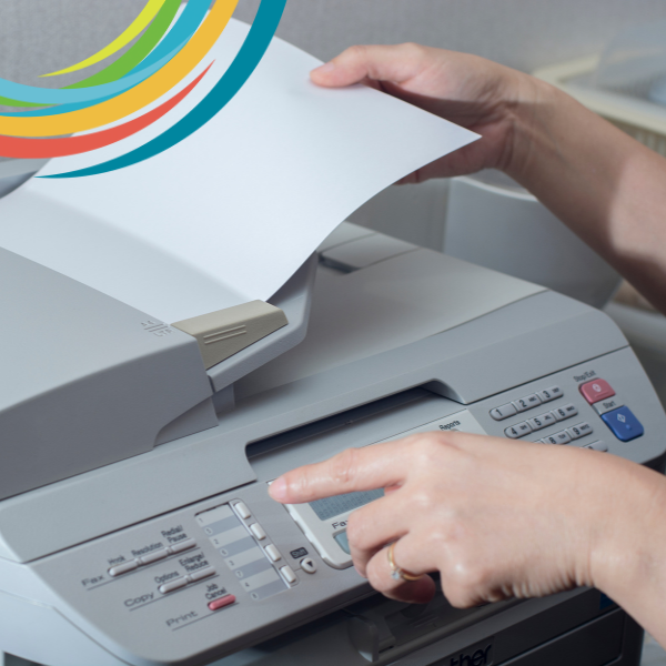 Picture of hands placing paper in fax machine and dialing number