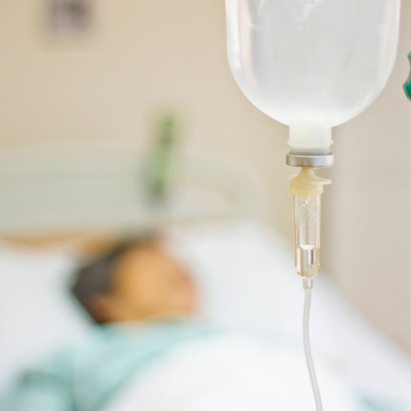 picture of man laying in hospital bed with IV drip