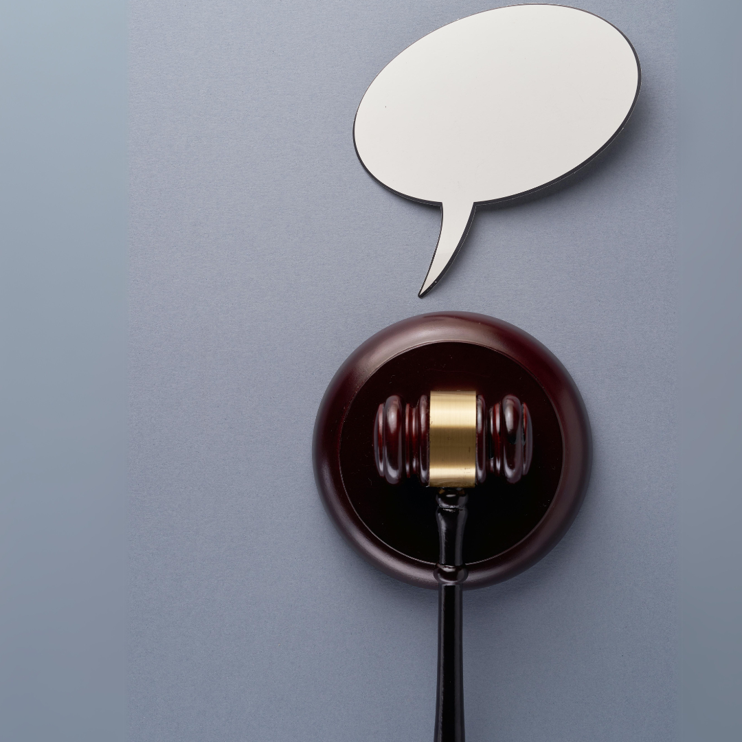 Brown wooden gavel with a gold band on the hammer part of the head, resting on a round platform; a white speech bubble sits above the gavel; Photo by eskay lim on Unsplash