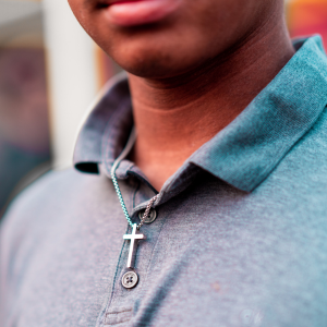 Picture of man in polo shirt wearing cross.  Only lower face, neck and chest are showing in picture.