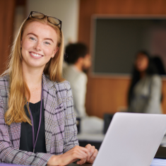 Picture of smiling young woman working on laptop