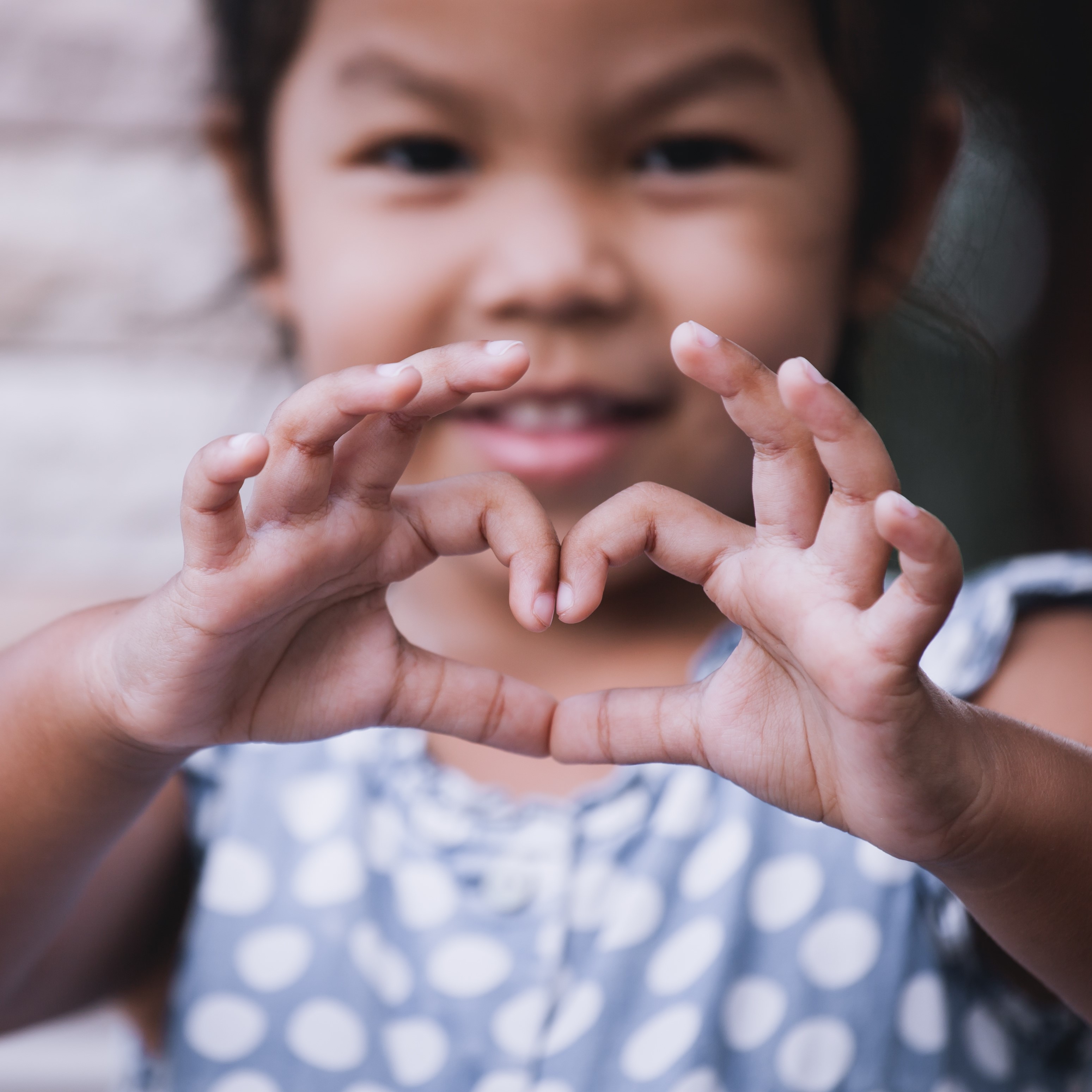 Picture of young girl making a heart sign with her hands