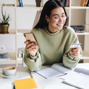 Smiling woman at her desk looking at gift card in her hand 