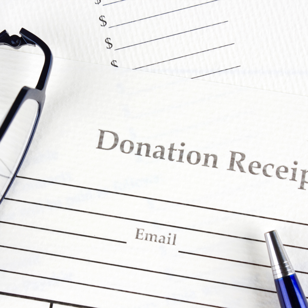 Picture of a donation receipt laying on table with glasses and pen