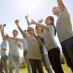 Picture of group of smiling people with arms raised in victory