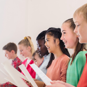 Picture of children standing and singing while holding sheet music