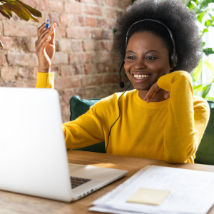 Smiling lady looking at her laptop with headphones on