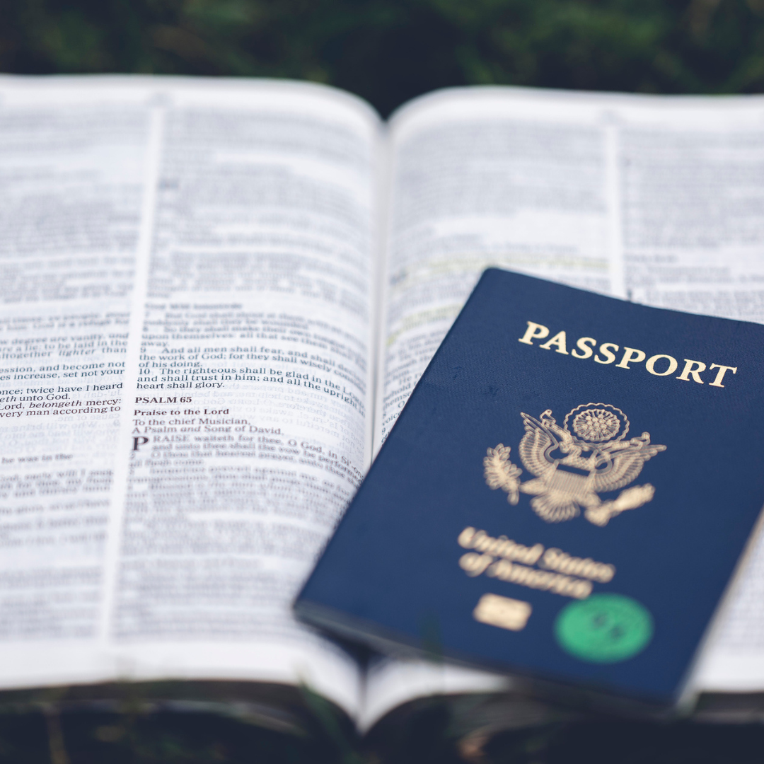 Picture of open Bible with a passport laying on top of it
