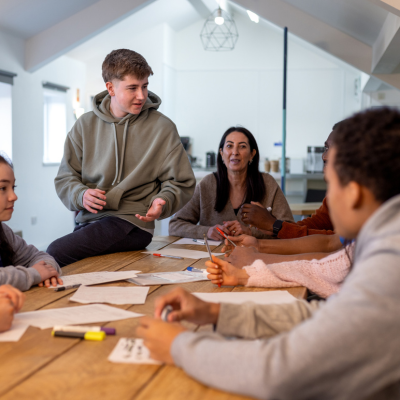group of people sitting around table talking some young and some middle age