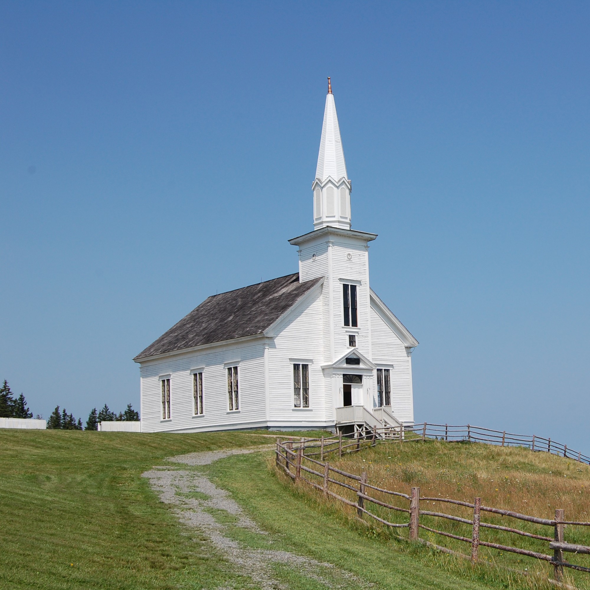 Picture of white wooden church in field of grass
