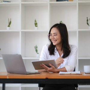Picture of smiling business women looking at ipad and laptop