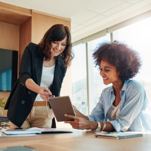 Picture of two smiling business women looking at ipad