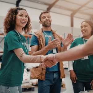 Picture of smiling volunteers shaking hands and clapping