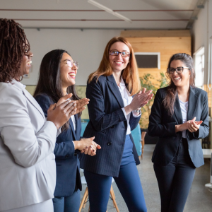 Picture of four business women standing and clapping