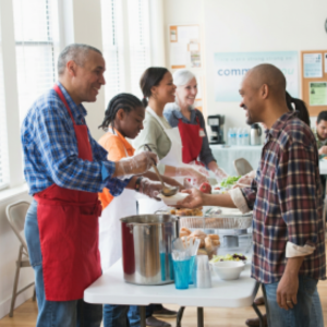 Group of smiling people man serving food to others