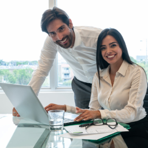 Smiling male and female colleagues looking at laptop