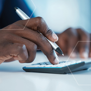 Picture of employee hands working on calculator holding a pen