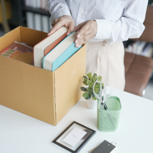 Picture of person putting personal office items in cardboard box