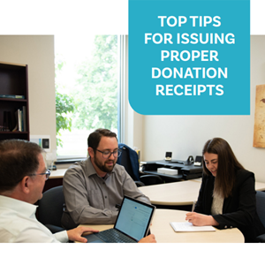 Picture of the three colleagues working around a table with the words Top Tips for Issuing Proper Donation Receipts