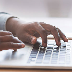 man's hands typing on keyboard