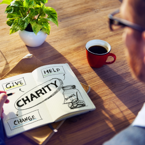 Man looking at Charity written in book