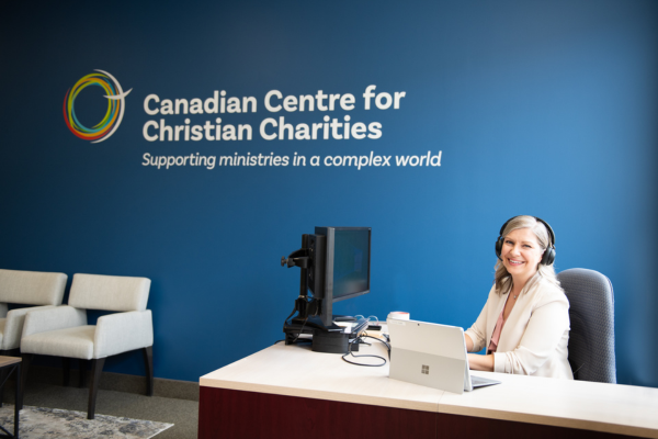 Picture of woman at reception desk with CCCC logo on wall in background