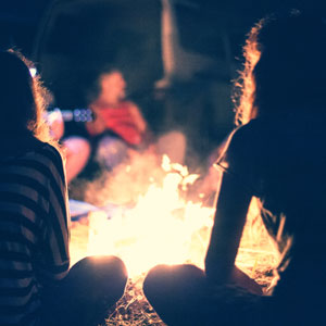 people sitting around a campfire