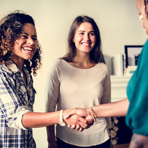 Women shaking hands and smiling