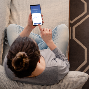 picture of woman sitting on couch reading on cellphone