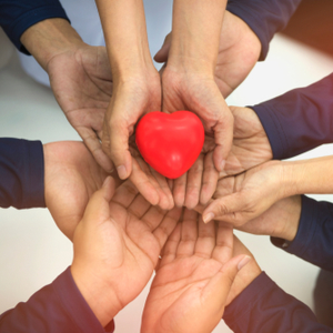 picture of hands in a circle together holding a heart