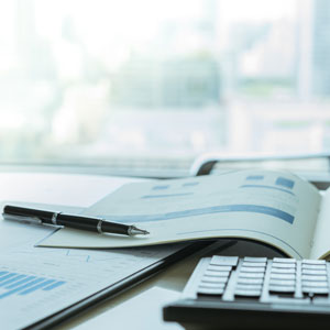 Picture of desk with company financials, calculator and pen