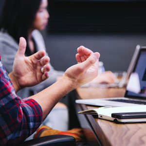 People in meeting gesturing with their hands