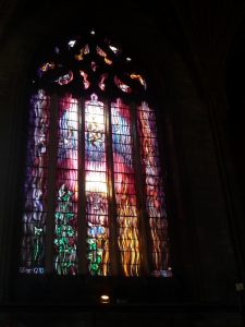 A beautiful modern stained glass window next to the organ case. The upper blue part of the window portrays organ pipes and the Holy Spirit descending. Yes! Organ music is the music of God!