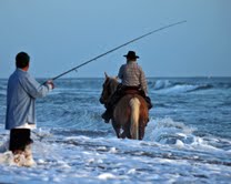 Cowboy on a horse in the water with a fisherman