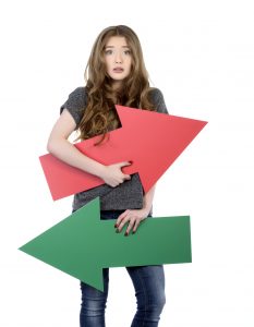 confused young woman with colorful arrows, casual clothes, blond hair, photo taken in studio shot on white background.