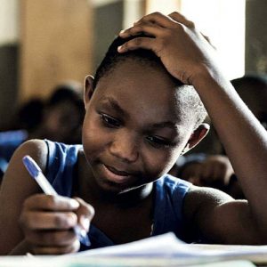 A student writes at a desk