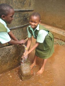 Two children get water from a well