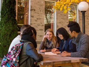 Students sitting at a picnic table outdoors